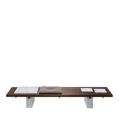 a wooden bench sitting on top of a white floor next to a brown and white wall