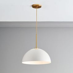 a white light hanging from the ceiling in a room with grey walls and flooring