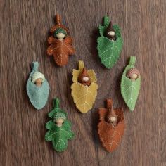 several small figurines made out of leaves and acorns on a table