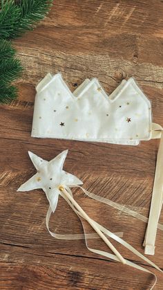 a white headband with gold stars on it next to a pine branch and other items