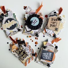 four halloween tags on a table with confetti and sprinkles