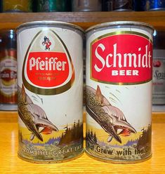 two beer cans sitting on top of a wooden table