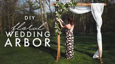 a woman standing in front of a wooden arch with greenery on it and the words diy floral wedding arbor