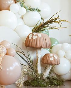 mushrooms and balloons in front of a wall with white, pink, and green decorations