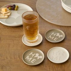 three coasters with the words home and mickey mouse on them next to a glass of beer