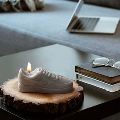 a pair of white sneakers sitting on top of a table next to a laptop computer