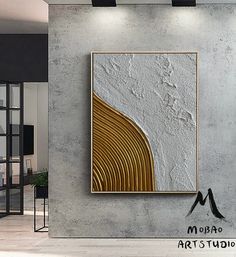 an abstract painting hangs on the wall next to a chair in a room with concrete walls and flooring