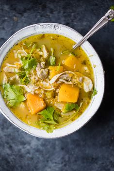 a white bowl filled with chicken and vegetable soup