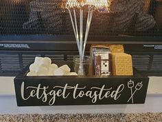 a wooden sign that says, let's get toasted and marshmallows