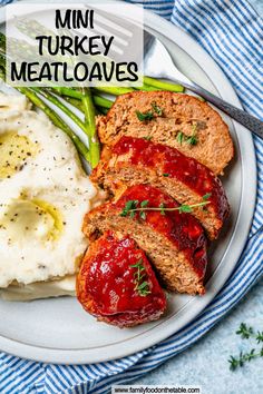 a plate with meatloaf, mashed potatoes and asparagus on it