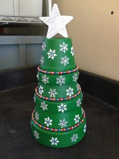 a green christmas tree with snowflakes on it and a star on the top