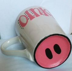 a pink pig coffee cup sitting on top of a white table