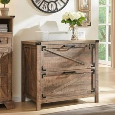 a clock on the wall next to a wooden cabinet with two drawers and an open door