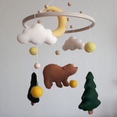 a mobile that has various items hanging from it's sides, including a bear and moon