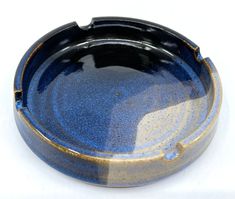 a black and blue bowl sitting on top of a white table