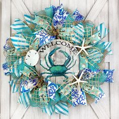 a blue and white wreath with a crab on the front door, welcome to us