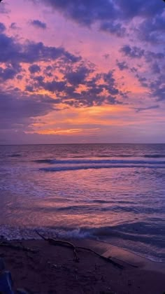 the sun is setting over the ocean with clouds