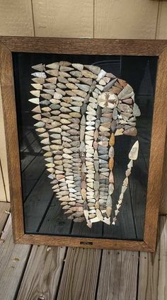 a wooden frame with shells in the shape of a woman's head on it