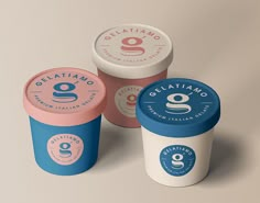 three ice cream cups with different flavors and designs on the top one is blue, pink, and white