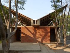 a brick building surrounded by trees on a sunny day