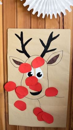 paper plate reindeer craft for kids with red nose and antlers on the front door