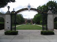 the entrance to an old brick and iron college campus