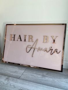 there is a sign that says hair by amara on the wall next to a teddy bear