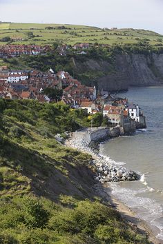 a small town on the edge of a large body of water next to a beach