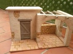 a toy house made out of clay with a door and brick walkway leading to it