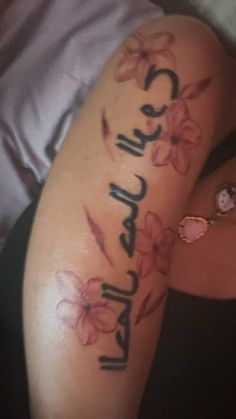 a woman's arm with flowers on it and the word love written in cursive writing