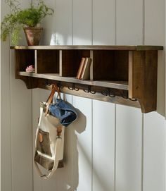 a wooden shelf with some books on it and a bag hanging from the wall next to it