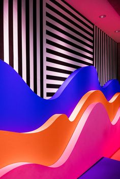 an abstractly designed room with black and white stripes on the wall, pink and orange waves