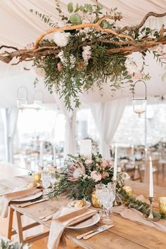 a wedding reception setup with white flowers and greenery