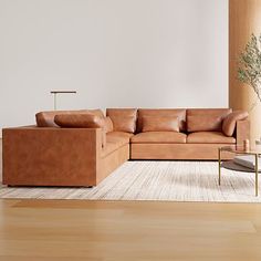 a living room with a couch, chair and table next to a plant in the corner