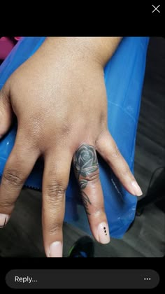 a woman's hand with tattoos on it and a blue object in the background