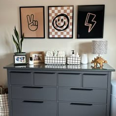 a dresser with pictures on the wall above it