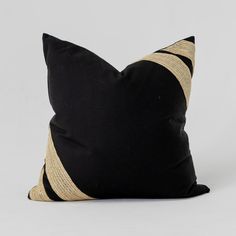 a black and gold pillow sitting on top of a white table