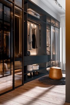 a walk in closet filled with lots of clothing and shoes next to a large window