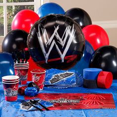 the table is set up with balloons, cups and napkins for an wwe birthday party