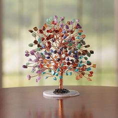 a colorful tree sculpture sitting on top of a wooden table