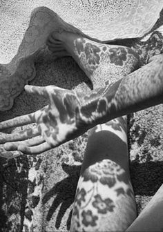 a woman laying on the ground with her arm and leg covered in leopard print fabric