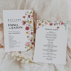 two wedding programs with flowers on them sitting next to each other in front of a white sheet