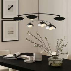 a dining room table with vases and pictures on the wall