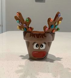 a ceramic cup with reindeer's head on it sitting on top of a counter