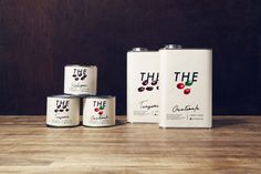 four cans of yogurt sit next to each other on a wooden table,