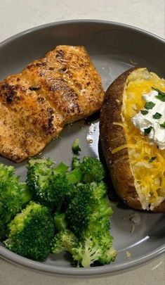 a plate with broccoli, chicken and bread on it next to a fork