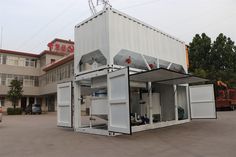 a large white container sitting in the middle of a parking lot next to a building