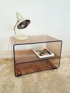 a table with a lamp on top of it and a magazine in front of it