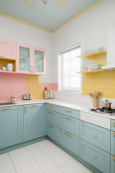 a kitchen with pastel blue cabinets and white counter tops, yellow trim around the edges