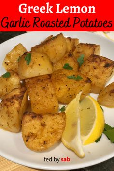 this is a plate of grilled potatoes with lemon wedges and parsley on the side